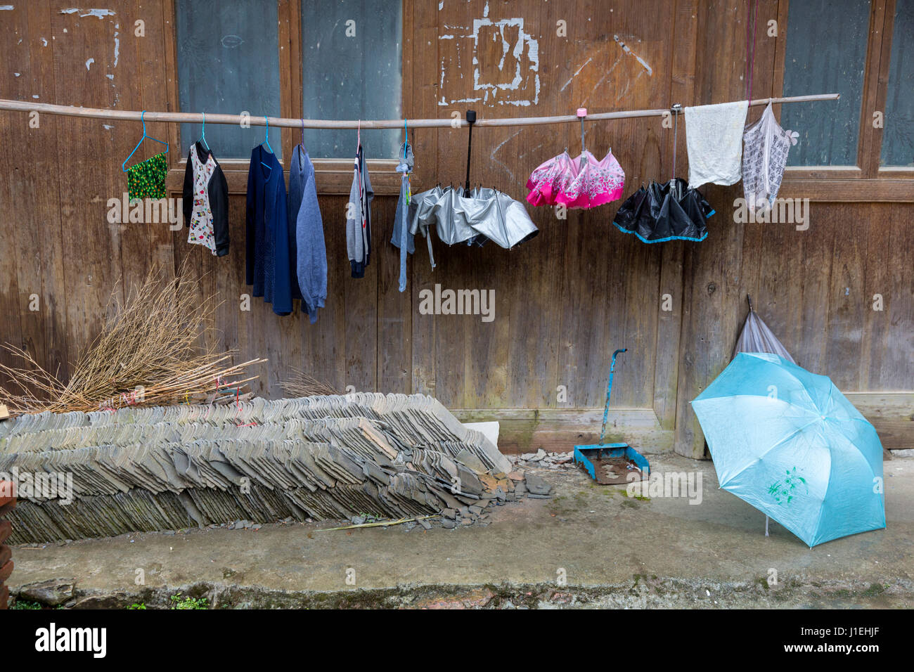 Huanggang, Guizhou, en Chine. Un village ethnique. Vêtements et des parasols tomber. Pour nouvelle toiture. Banque D'Images