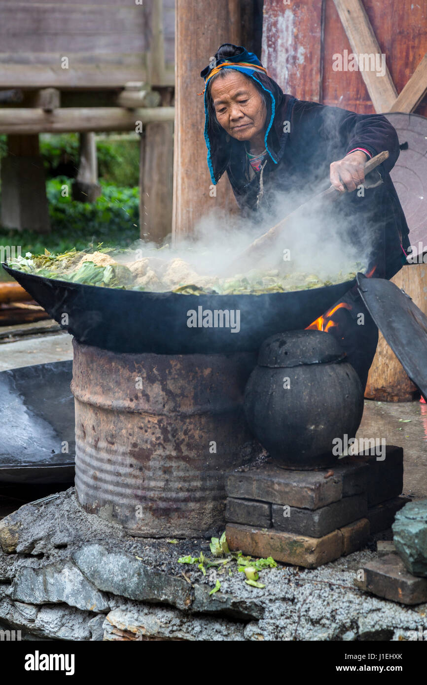 Huanggang, Guizhou, en Chine. Les femmes Dong pour la cuisson des aliments Porcs verts. Banque D'Images