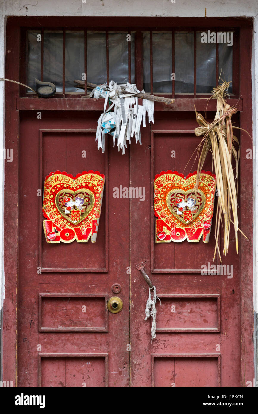 Huanggang, Guizhou, en Chine. Un village ethnique. Décorations de porte la célébration d'un mariage récent, conjurer les mauvais esprits. Banque D'Images