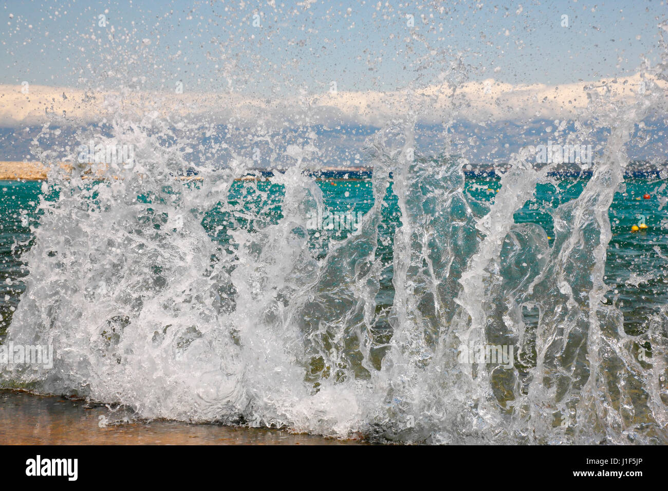 Les vagues éclaboussant rock sur la plage Banque D'Images