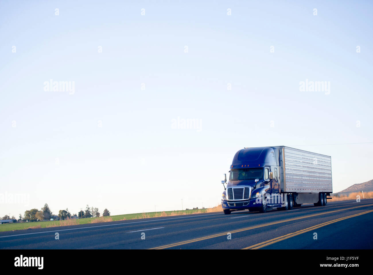Moteurs puissants énorme moderne bleu foncé populaires gros camion semi-remorque avec une chambre séparée et un pourtour sur une surface plane de la Route Autoroute Banque D'Images