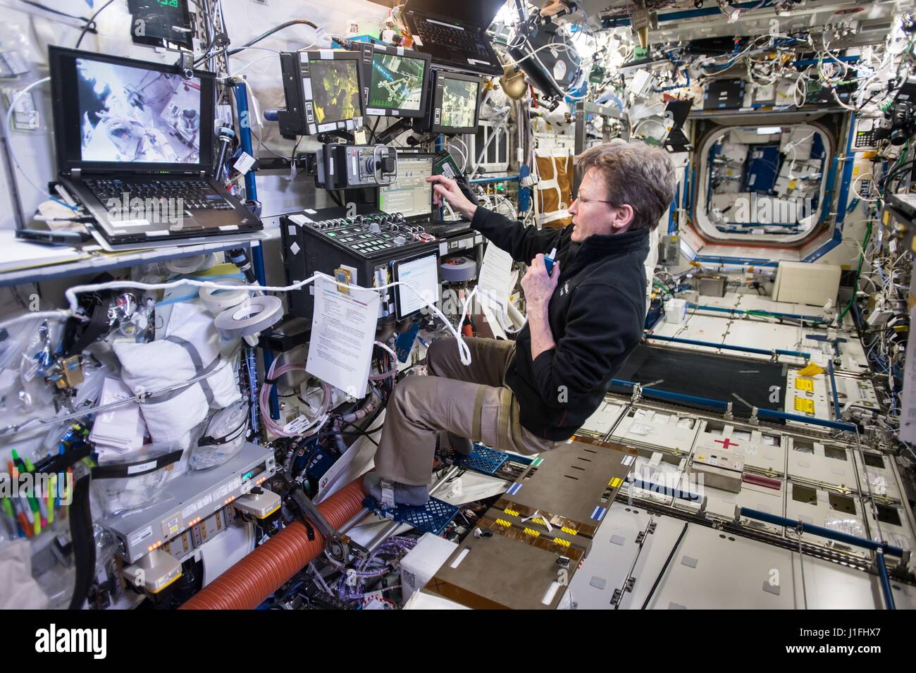 Expédition de la NASA 50 premier membre d'équipage l'astronaute américaine Peggy Whitson contrôle le bras télémanipulateur Canadarm2 de la Station spatiale internationale alors que les membres d'équipage Shane Kimbrough et Thomas Pesquet mener une activité extravéhiculaire sortie dans le 24 mars 2017, dans l'orbite de la Terre. (Photo de la NASA NASA /photo via Planetpix) Banque D'Images