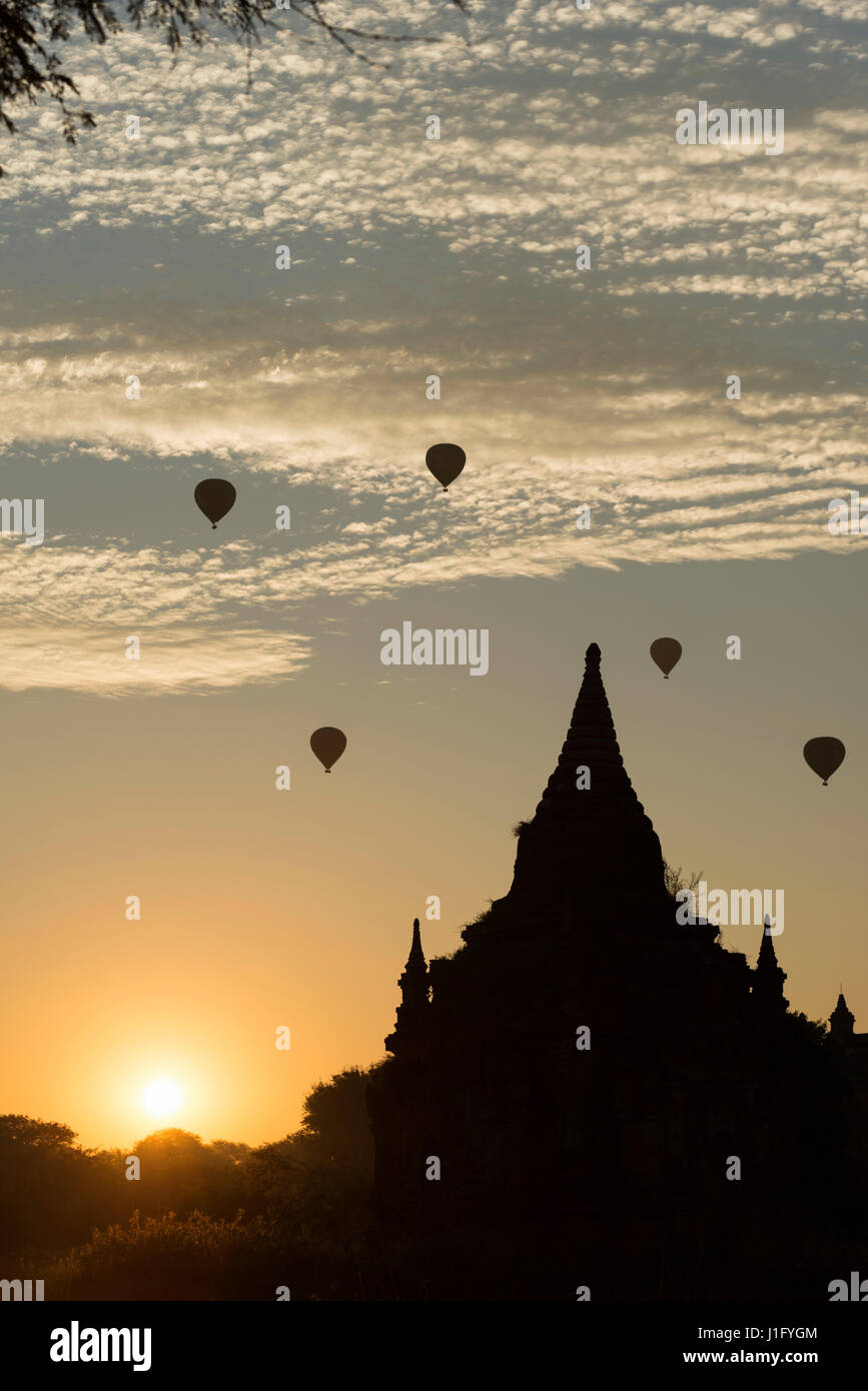 Hot air balloons Tha Beik Hmauk Gu Hpaya au lever du soleil, Bagan, Myanmar Banque D'Images