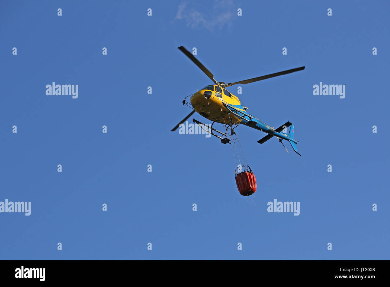 Les efforts de lutte contre l'incendie sont en cours avec des hélicoptères pour éteindre les incendies de forêts au-dessus de Gordola, Tessin, Suisse, le 19 avril, 2017 Banque D'Images