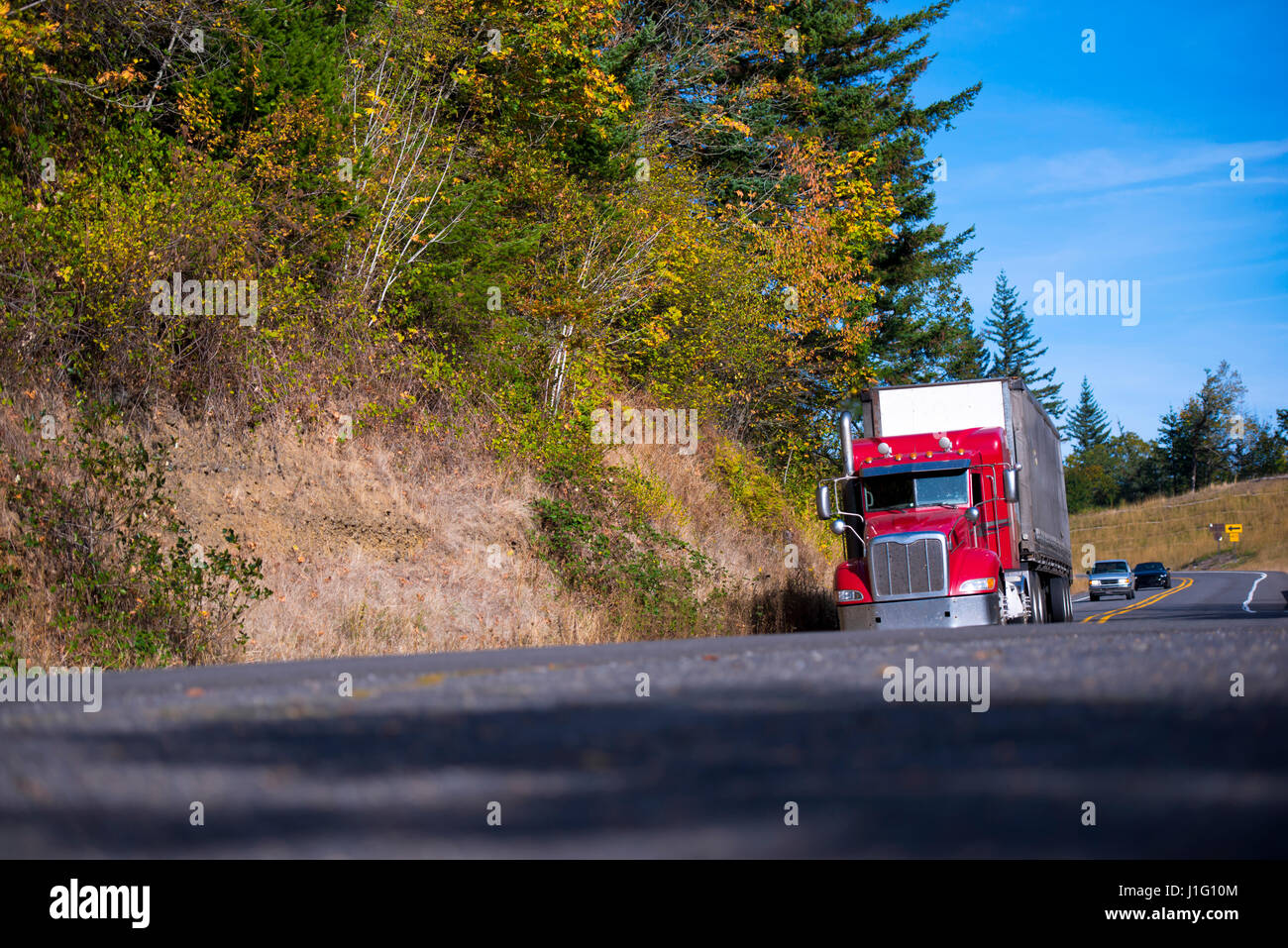 Le modèle classique d'un grand bâtiment moderne avec un camion semi remorque fourgon sec - excellent business unit Logistique transport déménagement sur route sinueuse Banque D'Images