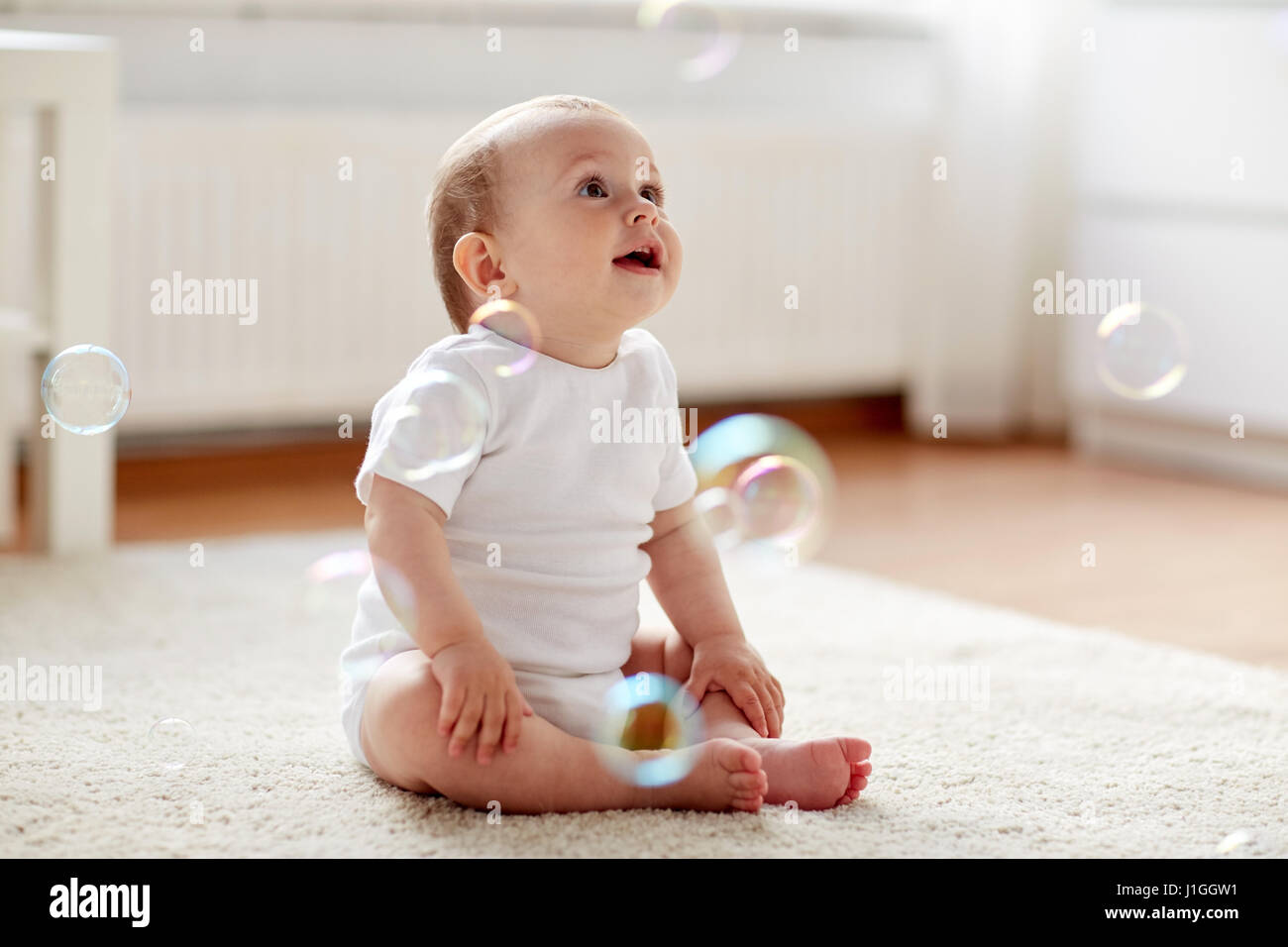 Happy Baby avec des bulles de savon à la maison Banque D'Images