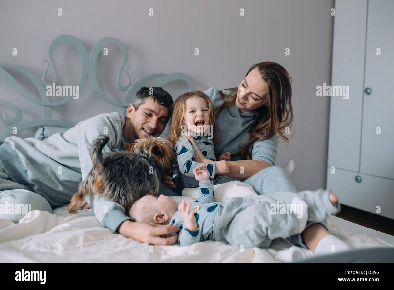 La mère, le père, la fille et le bébé sur le lit Banque D'Images