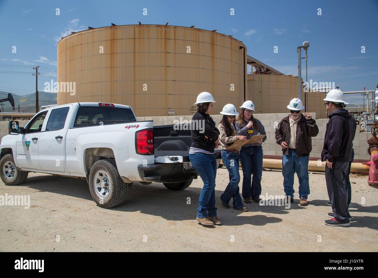 Un Bureau fédéral de l'équipe de gestion des terres inspecte les réservoirs de stockage de pétrole brut dans le champ de pétrole de Kern River le long de la vallée de San Joaquin, 11 avril 2017 à Bakersfield, Californie. Les puits de pétrole et de gaz qui couvrent la région sont sur des terres publiques louées par le gouvernement fédéral à l'industrie privée. Banque D'Images