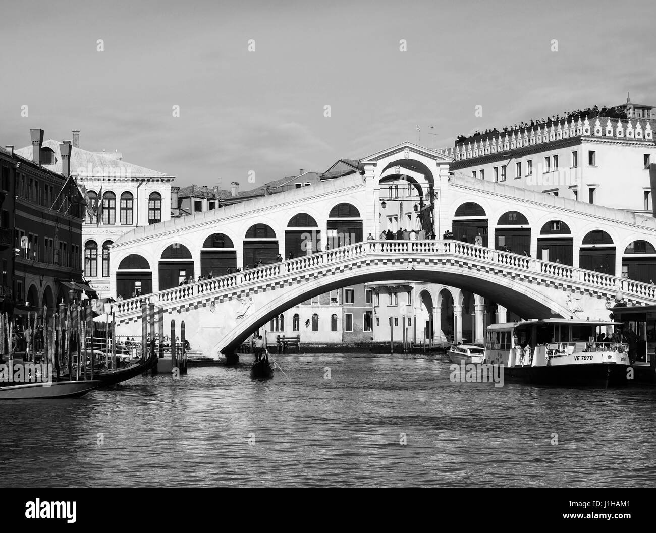 Le pont du Rialto à Venise sur une journée ensoleillée avec des bateaux et des bâtiments Banque D'Images