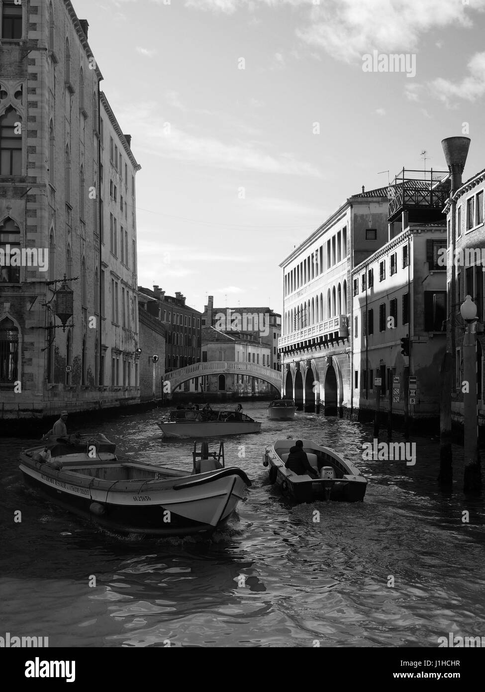 Canal in venice avec pont et deux bateaux de passage Banque D'Images