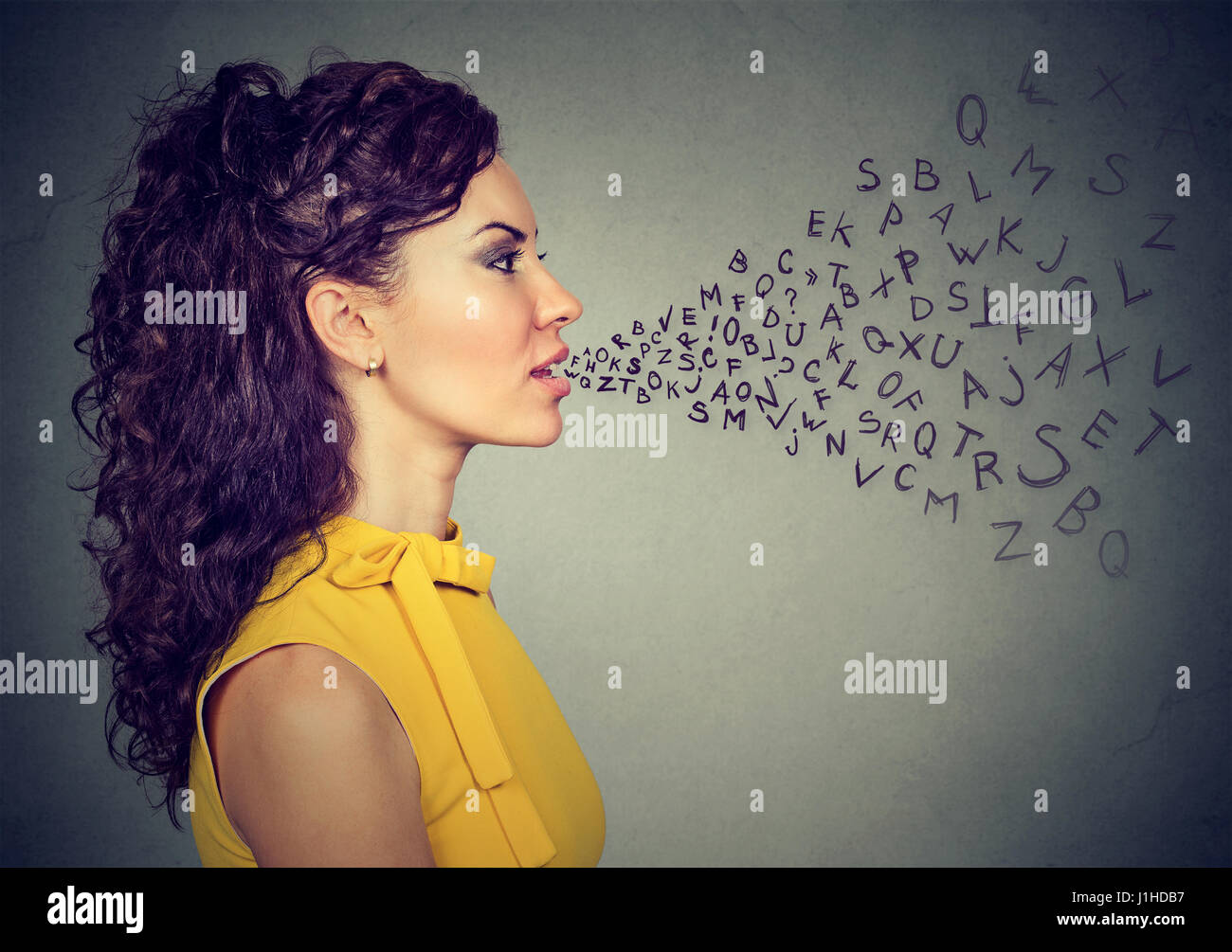 Femme parlant avec lettres de l'alphabet qui sortent de sa bouche. Communication, information, intelligence concept Banque D'Images