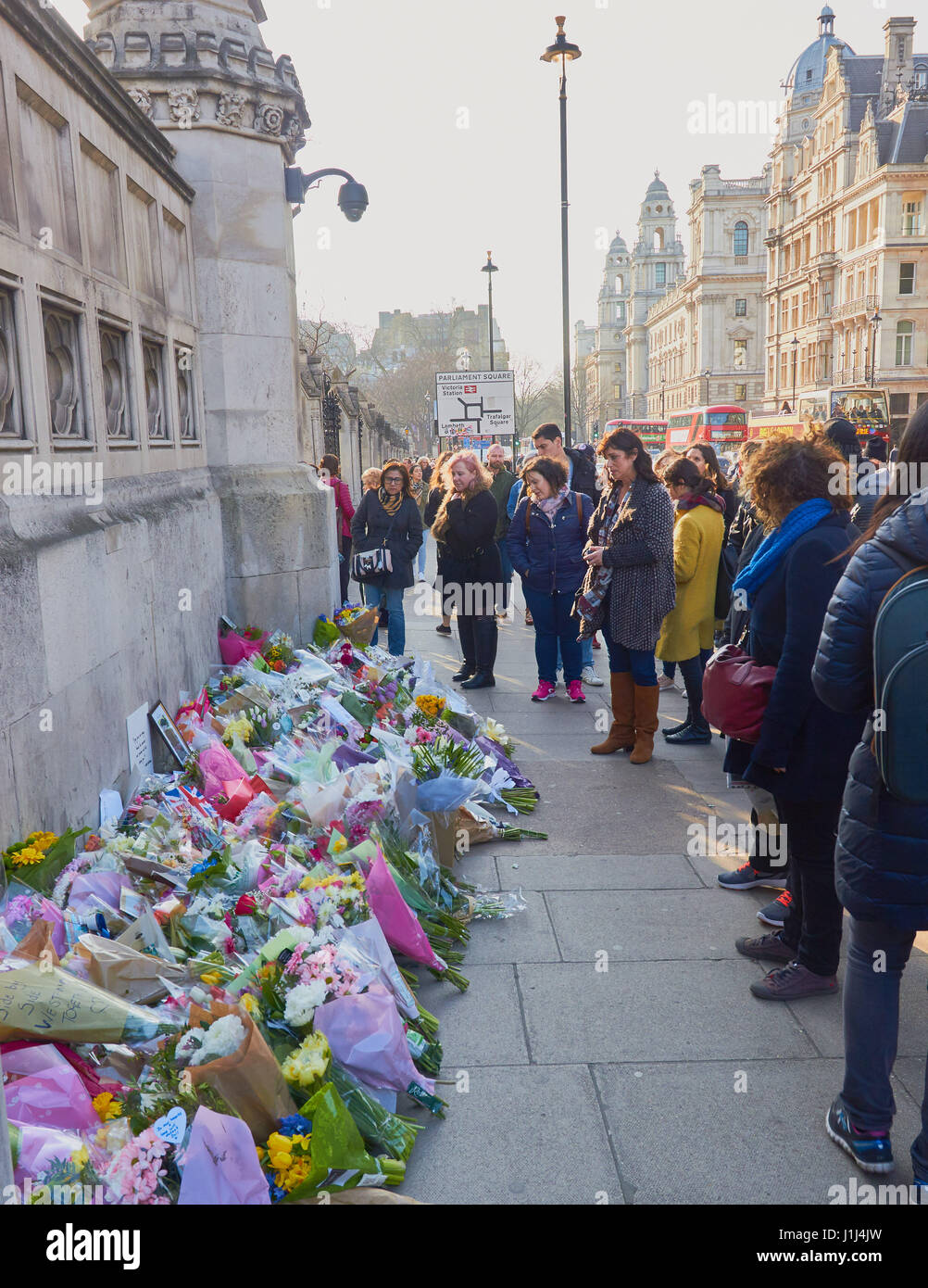 Les touristes et les Londoniens à la recherche au tributs floraux pour les victimes de l'attaque terroriste de Westminster, Westminster Bridge, Londres, Angleterre Banque D'Images