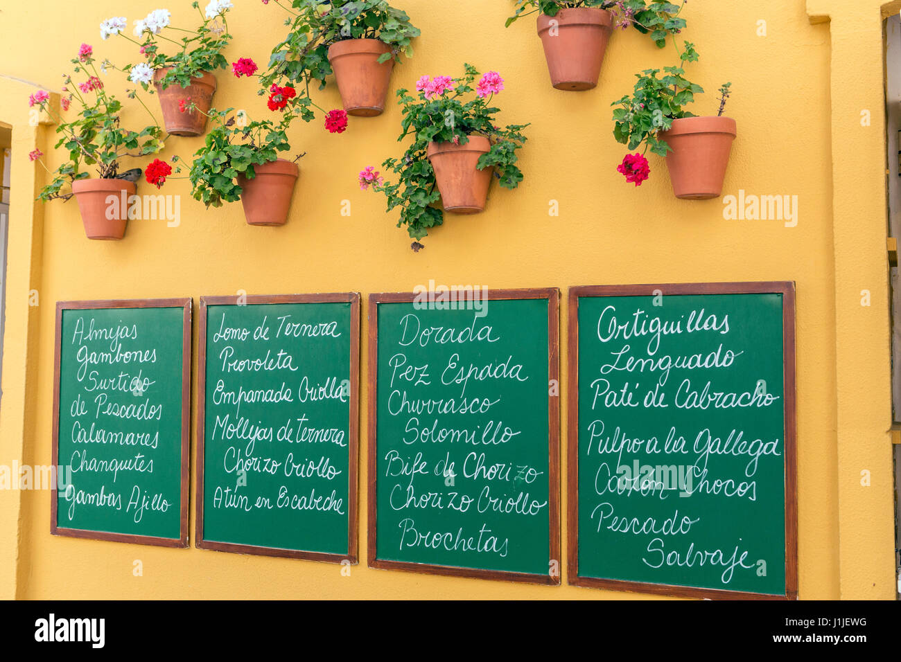 Poster d'ardoise écrit avec le menu des restaurants typiques, une décoration très colorée et des pots andalouse de Cadix, Andalousie, Espagne Banque D'Images