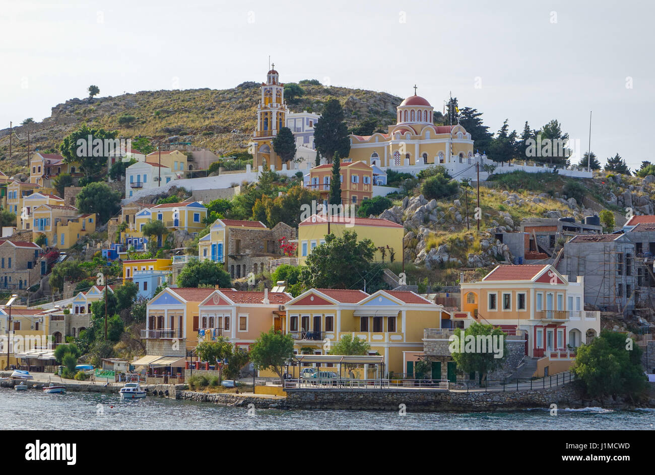 Maisons au bord de l'eau colorée sur Symi Simi, Grèce Banque D'Images