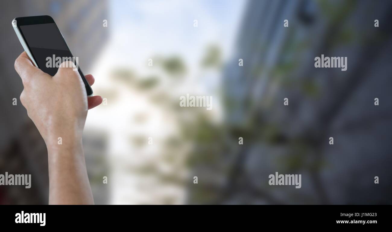 Digital composite de pair avec le téléphone contre les bâtiments et le ciel flou Banque D'Images