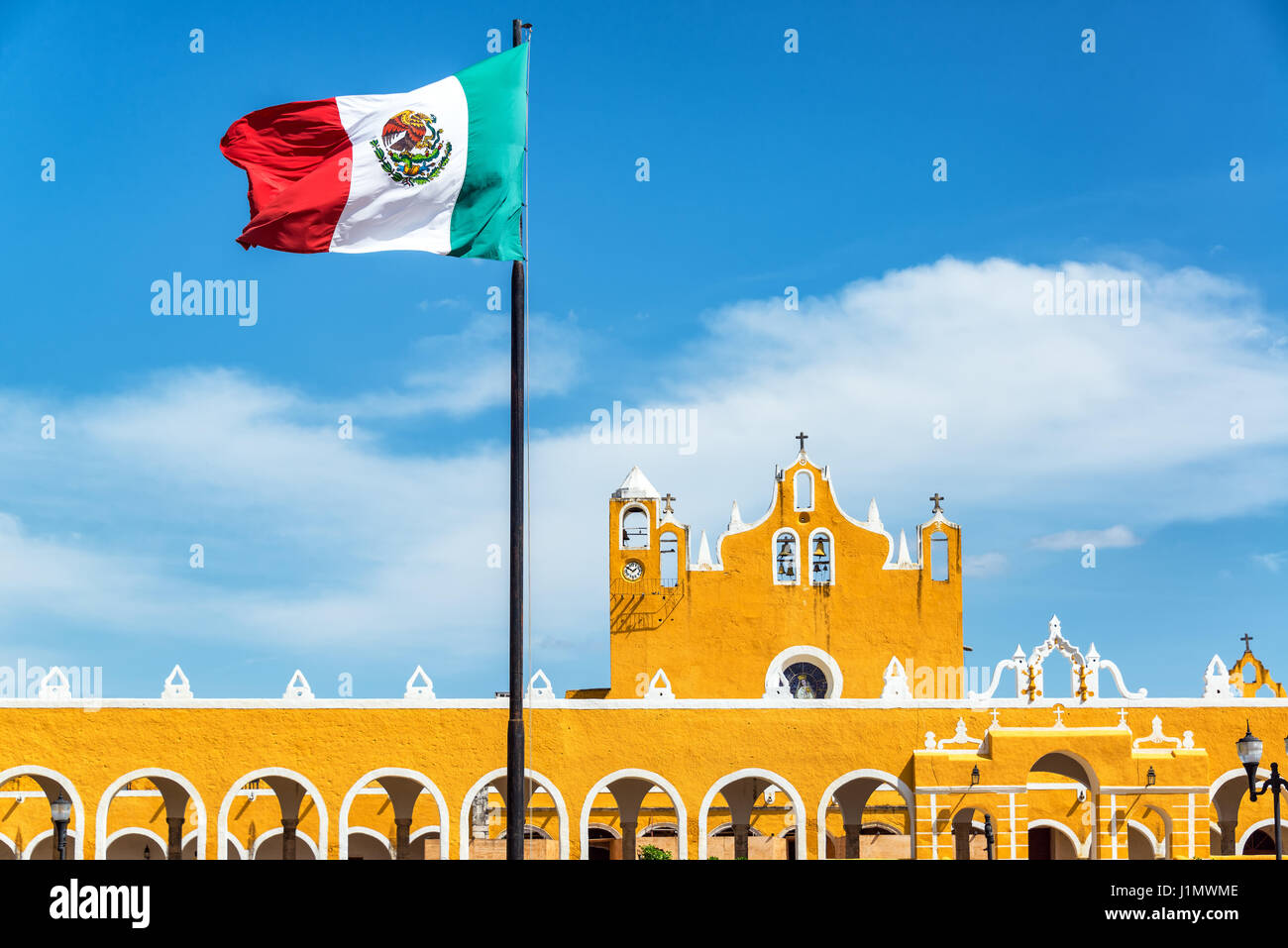 Monastère colonial jaune à Izamal, au Mexique avec le drapeau mexicain volant au-dessus Banque D'Images