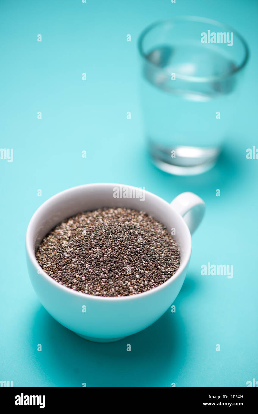 Verre d'eau et des graines de chia dans une tasse. L'espace du texte. Banque D'Images