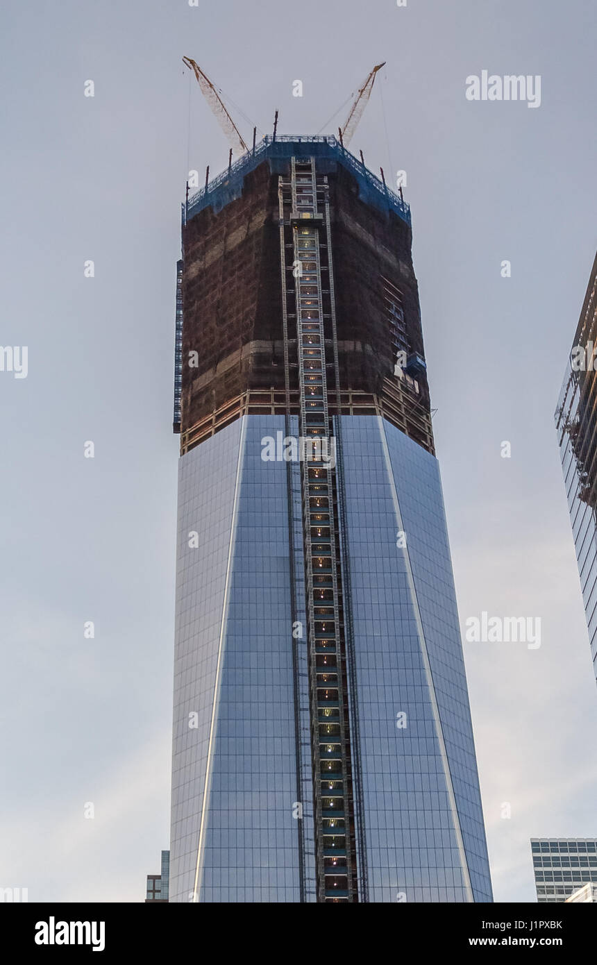 New York, USA - 3 décembre 2011 : Sommet de la presque fini seule tour World Trade Center avec ciel bleu et du site de construction Banque D'Images