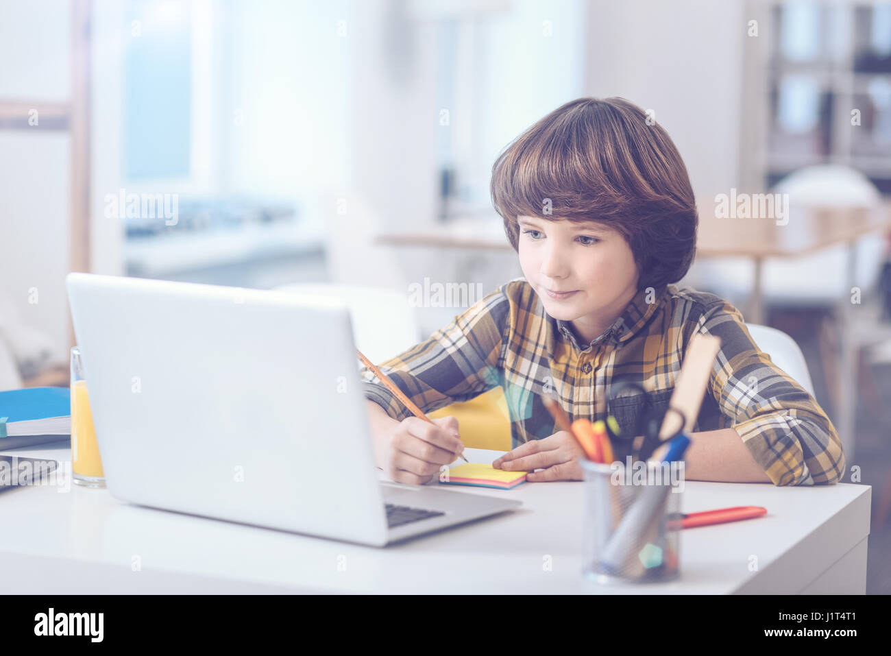 Pre-adolescent en prenant des notes pendant ses études Banque D'Images