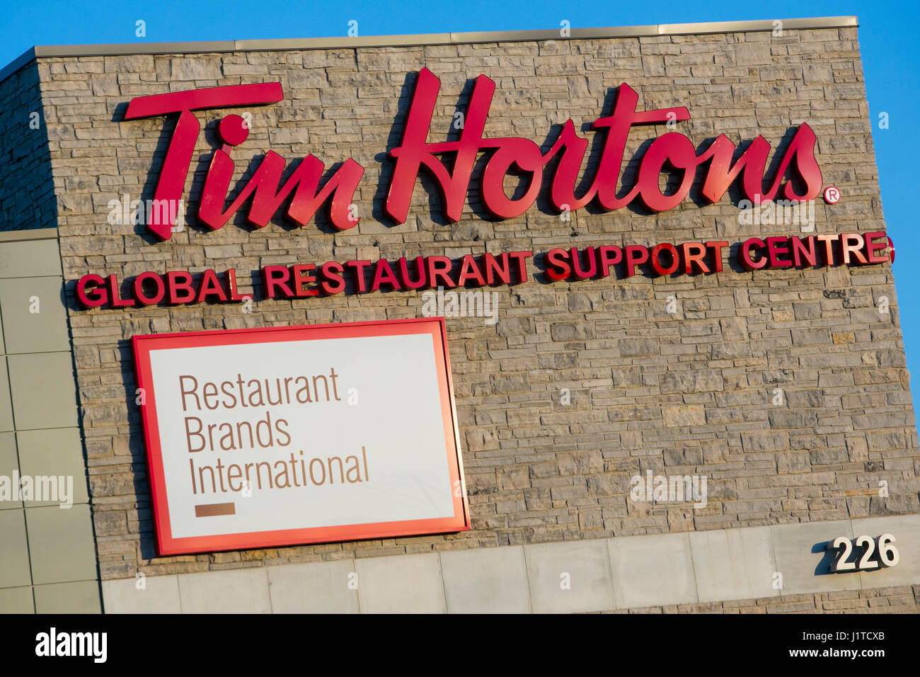 Un logo affiche à l'extérieur du siège de Restaurant Brands International, la société mère de Tim Hortons et Burger King, à Oakville, ON, Canada Banque D'Images