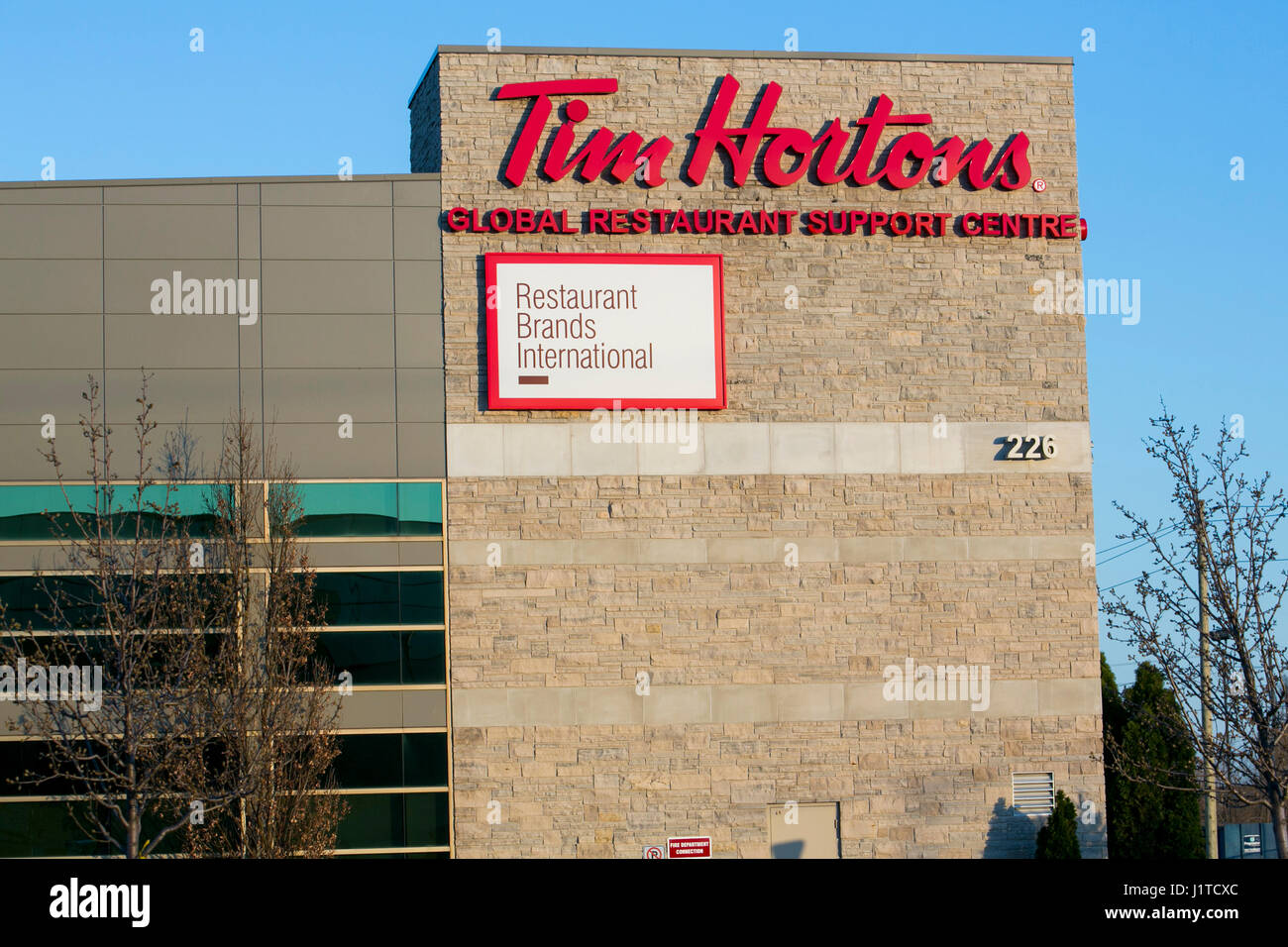 Un logo affiche à l'extérieur du siège de Restaurant Brands International, la société mère de Tim Hortons et Burger King, à Oakville, ON, Canada Banque D'Images