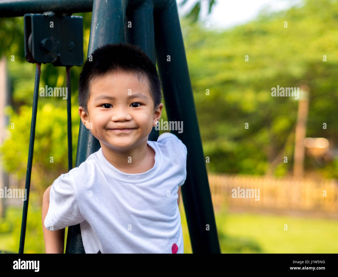 Enfant chinois (garçon) grimper sur les balançoires Banque D'Images