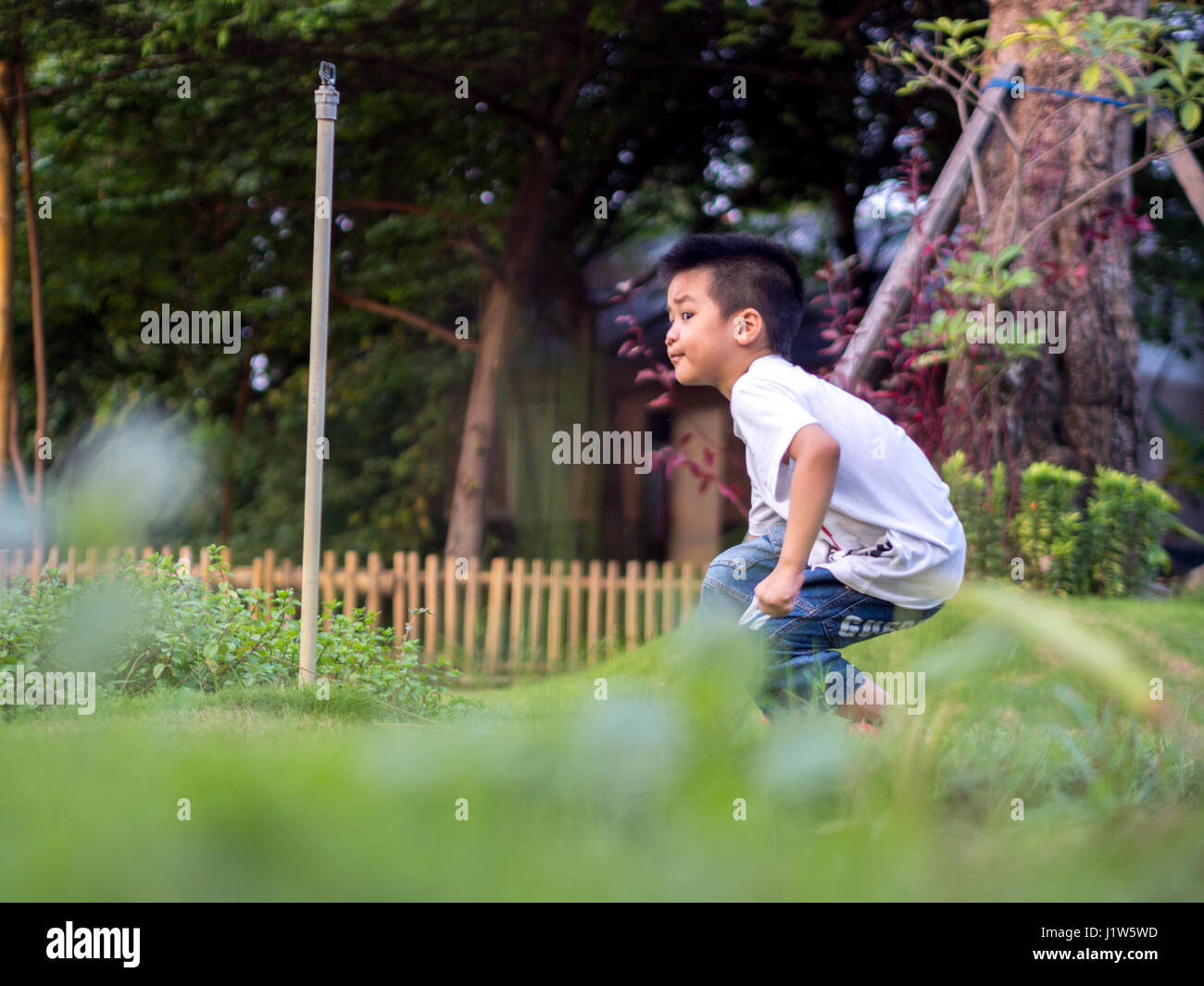 Enfant chinois (garçon) Crouch sur le parc Banque D'Images