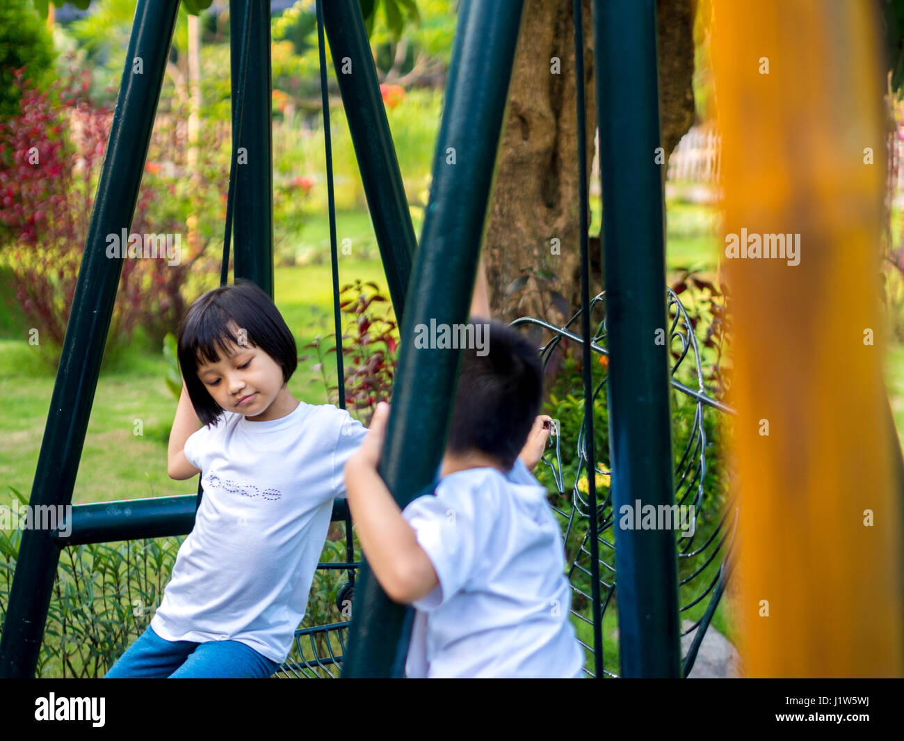 Les enfants chinois grimper sur les balançoires Banque D'Images