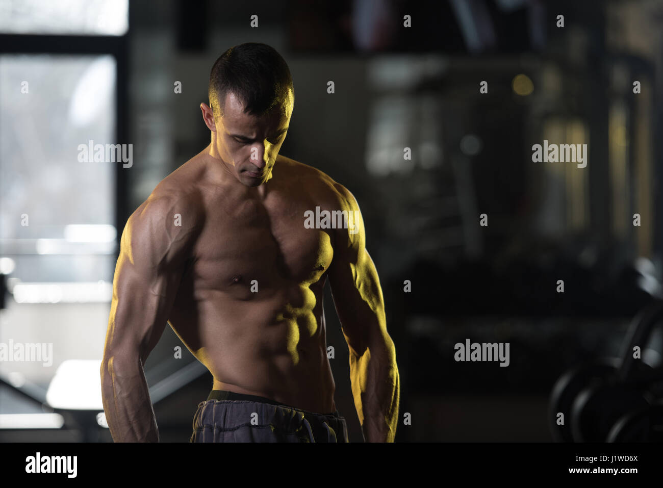 L'exercice de l'homme musclé muscles abdominaux avec les poids dans un club de remise en forme moderne Banque D'Images