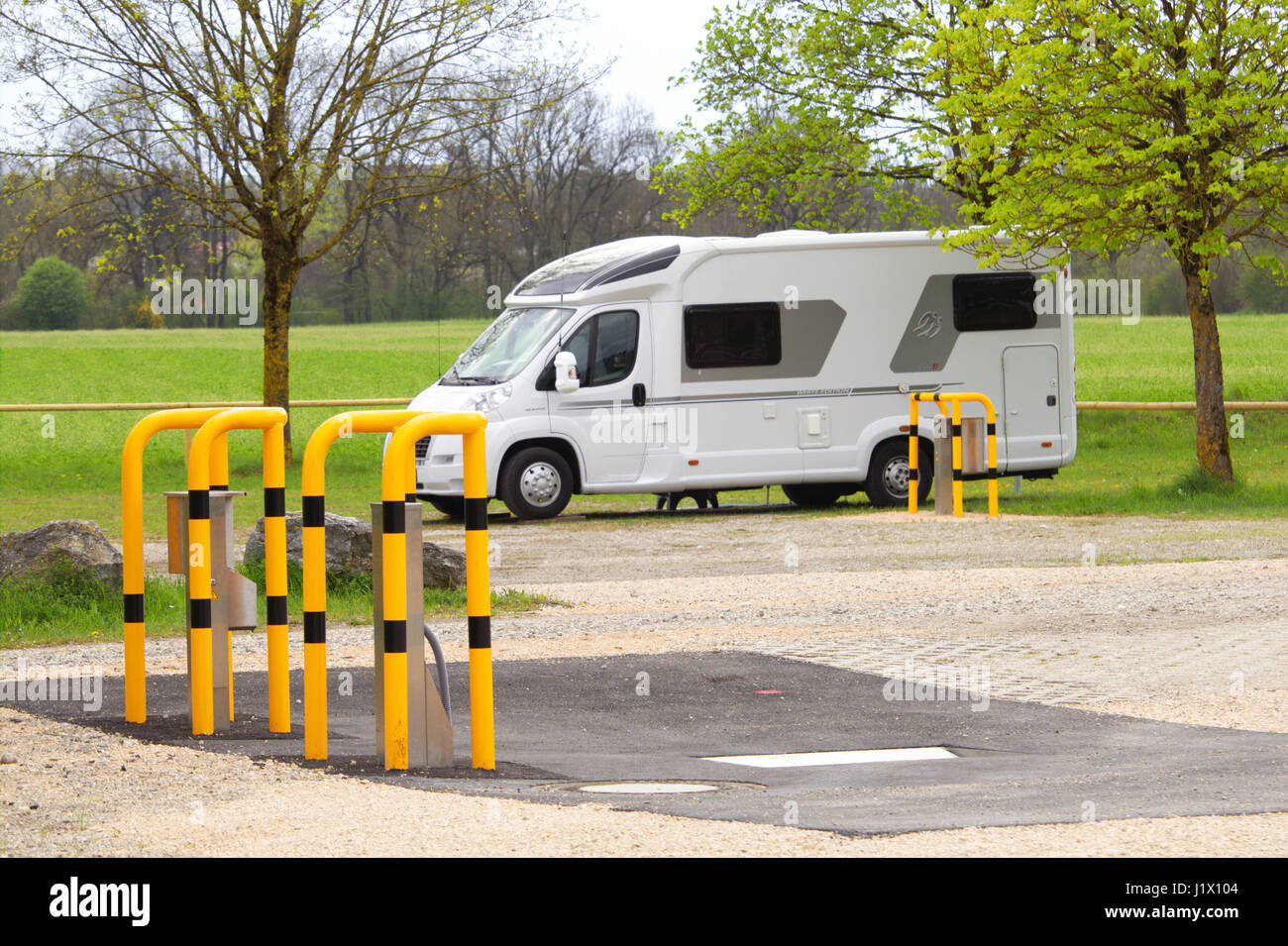 Ein Reisemobil steht auf dem Stellplatz , im Vordergrund Säulen mit Rammschutz für Frischwasserversorgung Kassetten-Entsorgung und, WC-Bodenablauf Banque D'Images