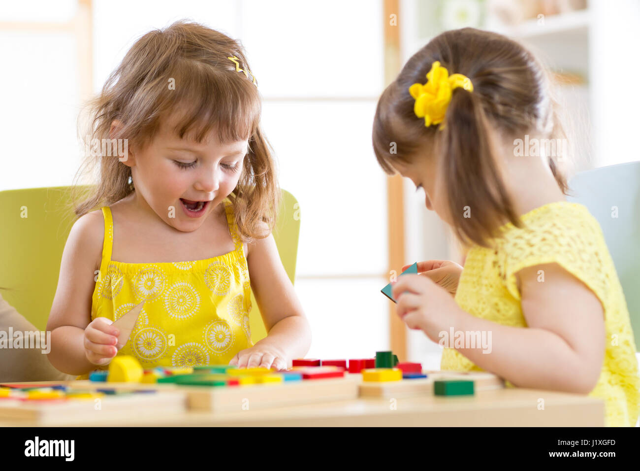 Les enfants jouent avec des jouets de bloc. Deux enfants filles à la maison ou de garderie. Jouets éducatifs pour enfants d'âge préscolaire et de la maternelle. Banque D'Images