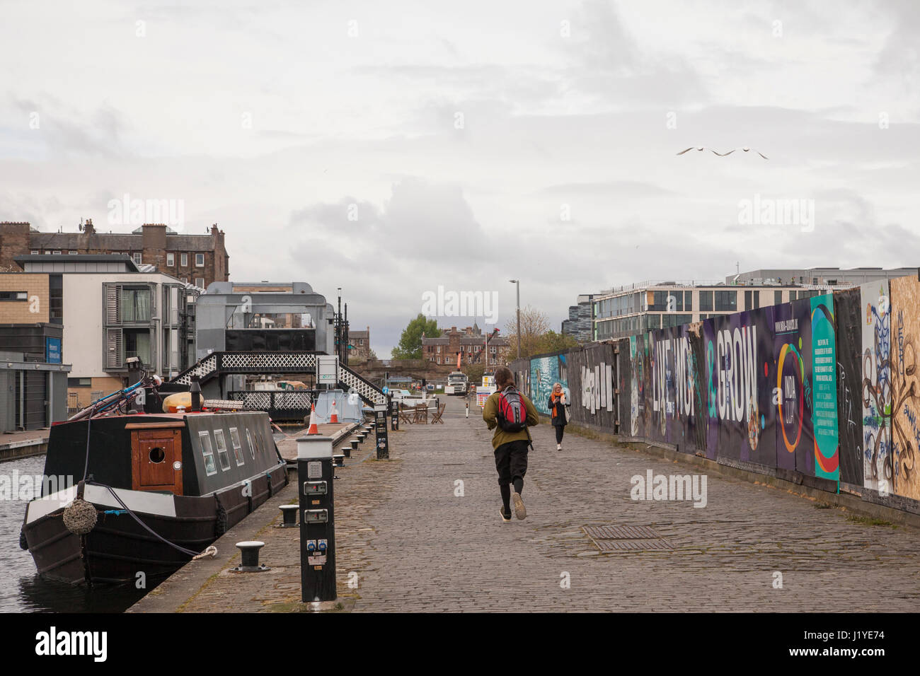 Homme qui court à côté de Union canal près de croix sans frais à Édimbourg, Écosse, Royaume-Uni, Angleterre. Météo : temps couvert avec éclaircies Banque D'Images
