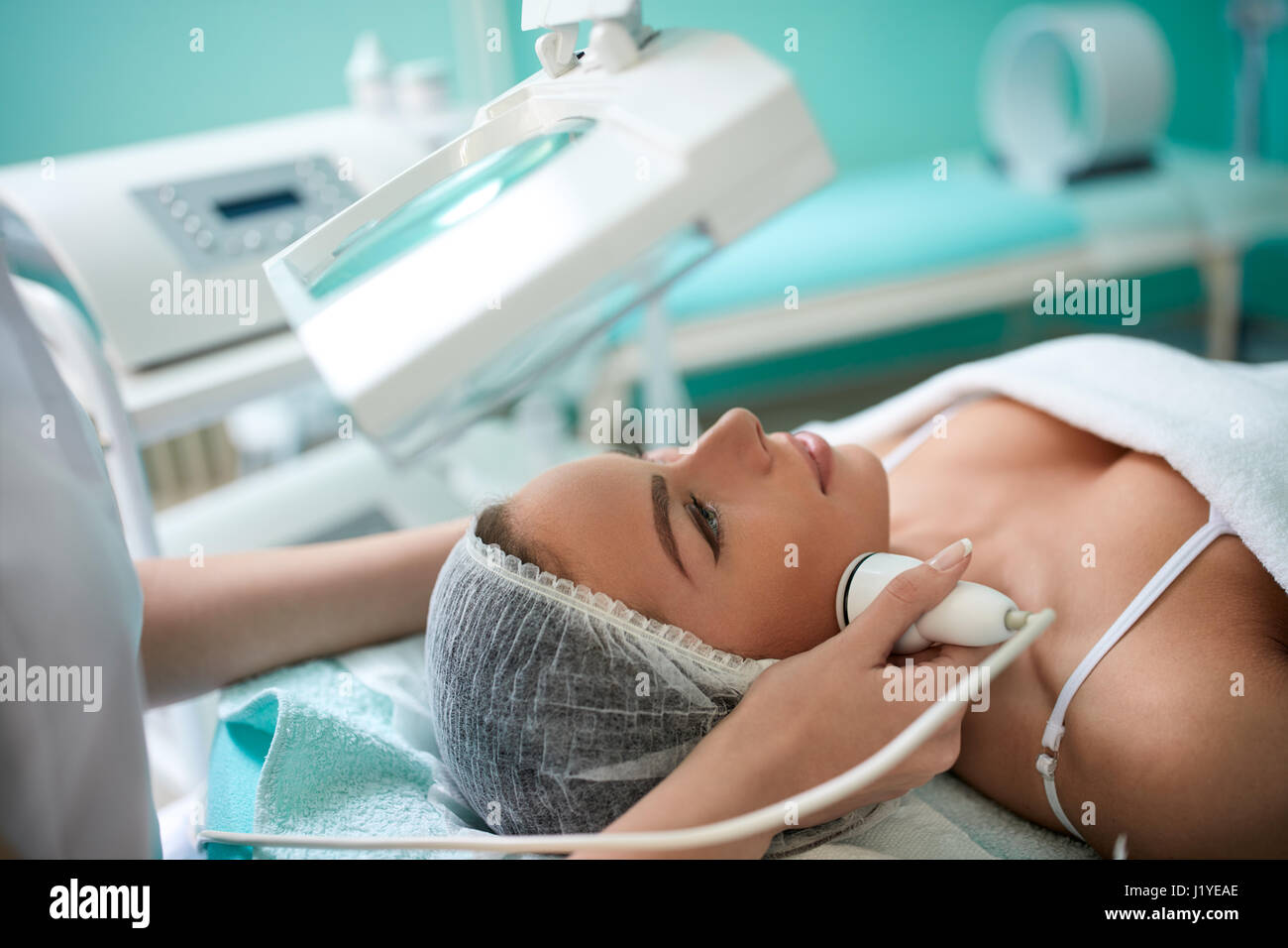 Close up of cosmetologist mains faisant 4D lifting laser visage et du corps sur le visage de femme Banque D'Images