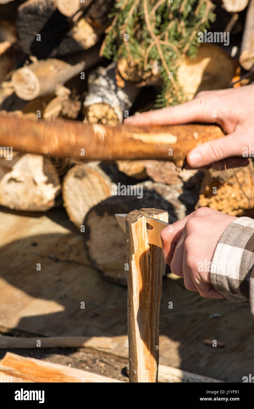 Homme fendre du bois d'abord avec de petits log et couteau de chasse. Banque D'Images