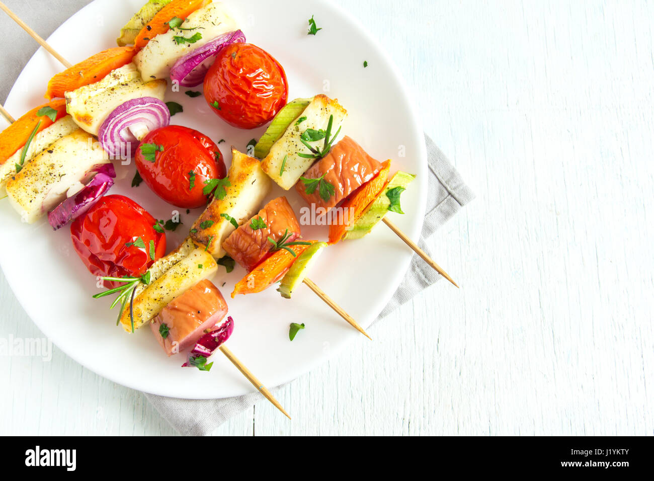 Brochettes de saucisses grillées et de légumes avec des herbes fraîches on white plate Banque D'Images