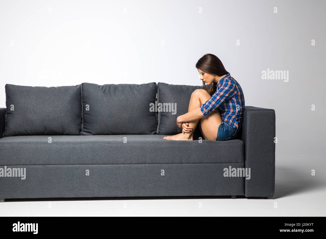 Déprimé triste femme au foyer, elle est assise sur le canapé la solitude Banque D'Images