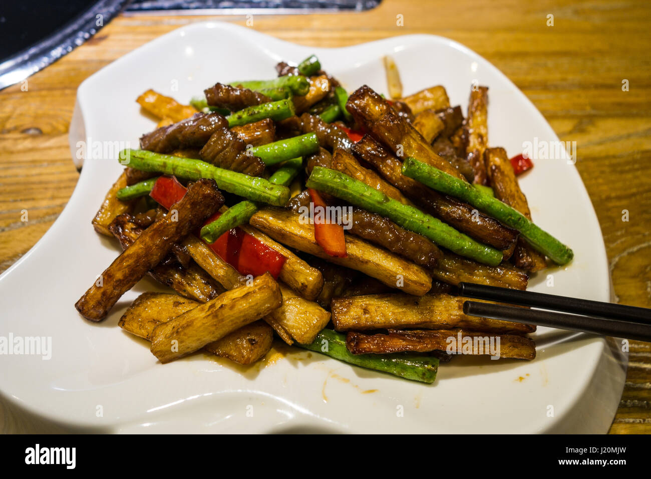 Sauté de boeuf chinois et de l'igname sur une plaque blanche Banque D'Images