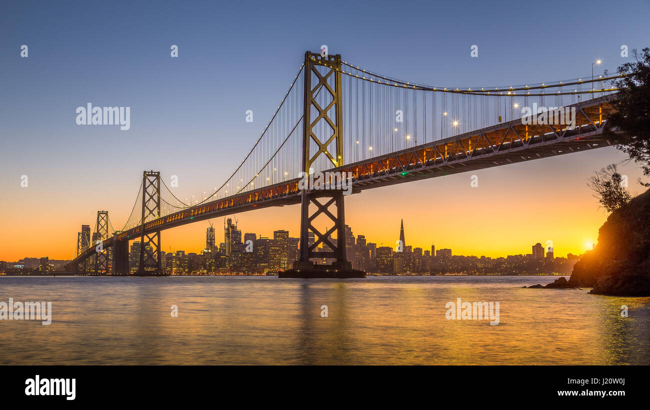 Classic vue panoramique de San Francisco skyline avec célèbre Oakland Bay Bridge illuminée en magnifique lumière du soir au coucher du soleil en été, San Banque D'Images