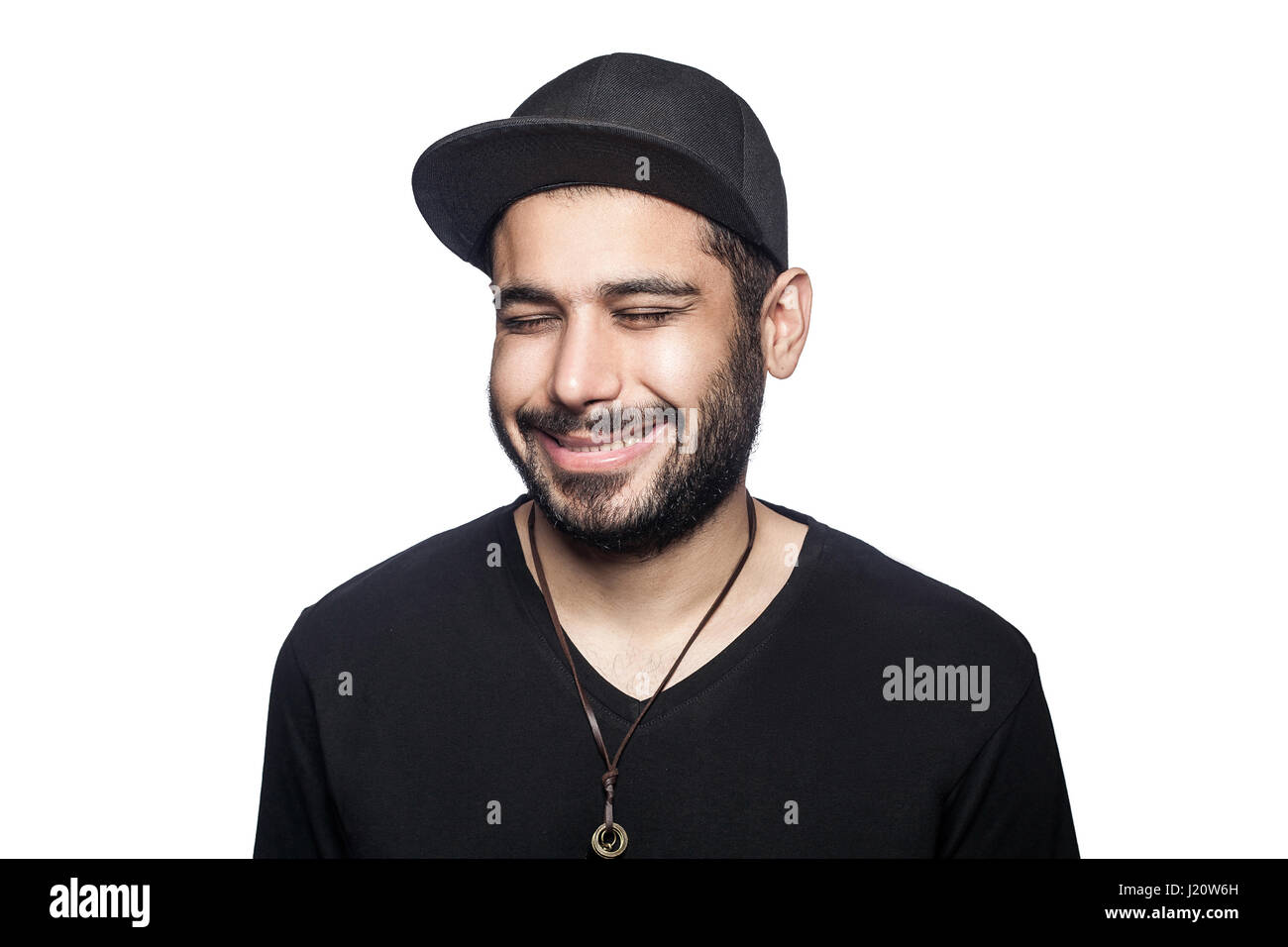 Portrait de jeune homme smilely heureux avec t-shirt noir et le chapeau avec les yeux fermés et sourire à pleines dents. studio shot, isolé sur fond blanc. Banque D'Images