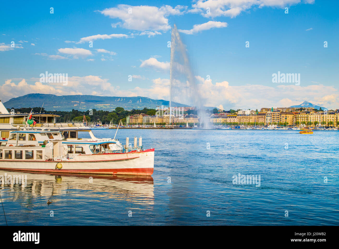 Vue panoramique de la ville de Genève historique avec le célèbre Jet d'eau et les navires à l'Harbour district dans la belle lumière du soir au coucher du soleil, Suisse Banque D'Images