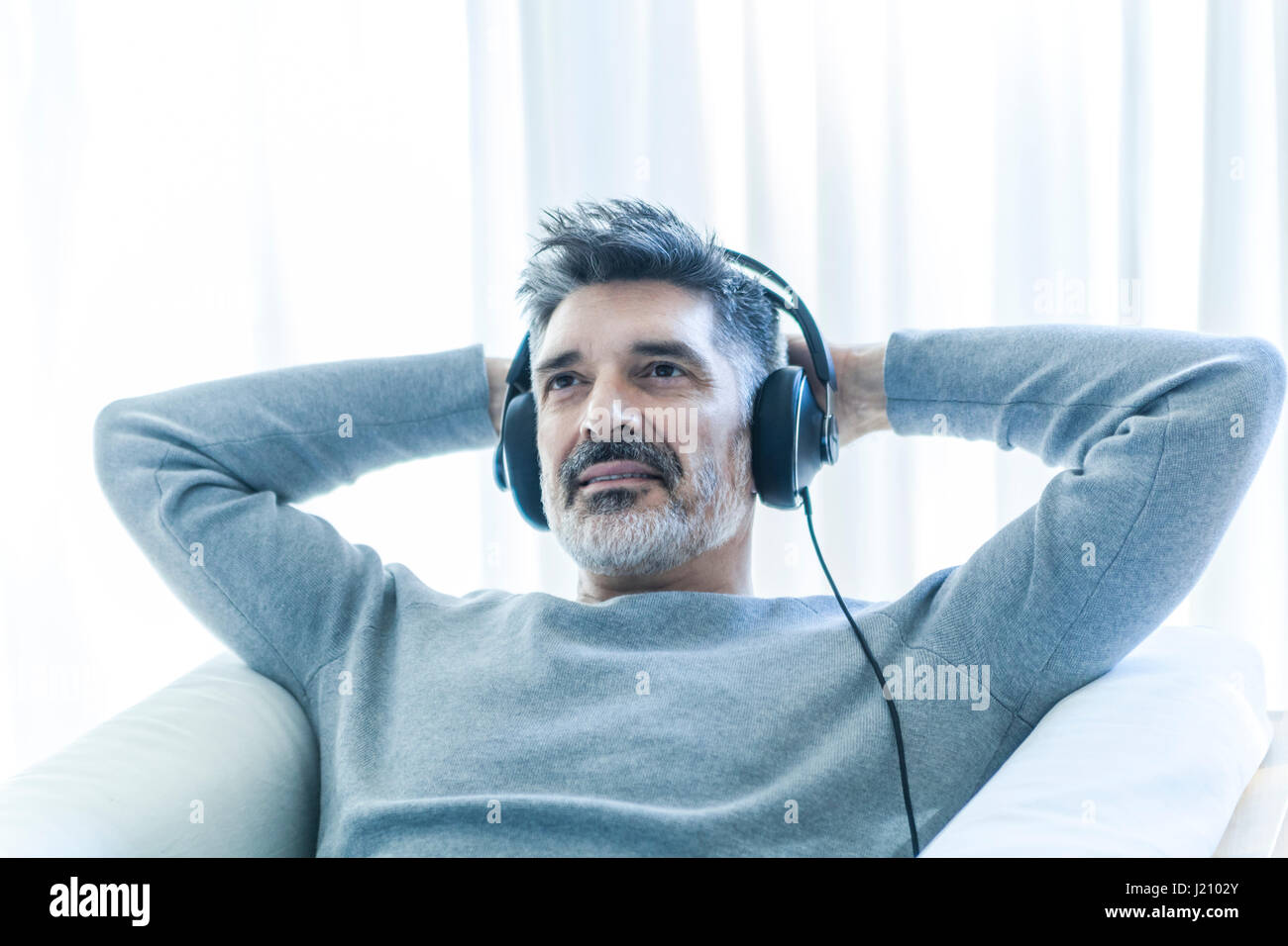 Relaxed mature man at home portant des écouteurs Banque D'Images