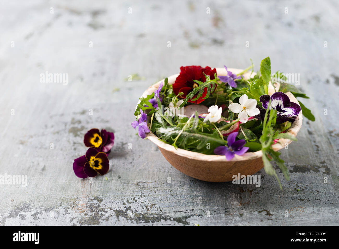 Bol de salade avec des feuilles de cresson, radis rouge et fleurs comestibles Banque D'Images