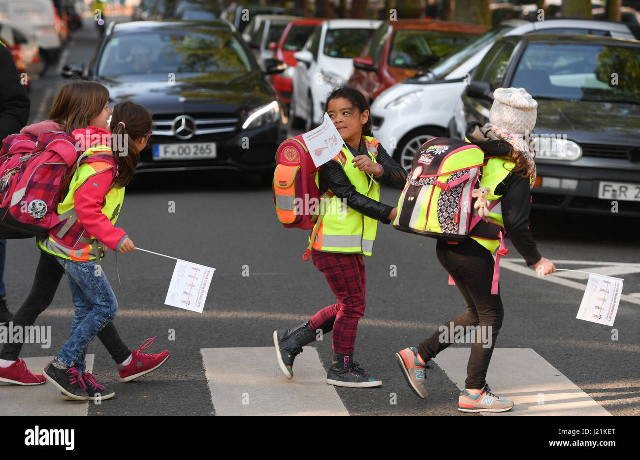 Les élèves traversent un passage piéton pendant un rassemblement à Frankfurt am Main, Allemagne, 21 avril 2017. Quelque 2 500 élèves, enseignants et parents ont formé une chaîne humaine à travers le quartier de Nordend dans le but de freiner la conduite dangereuse. Une initiative composée de représentants des parents des 5 écoles primaires et des commissaires de l'enfance avait appelé à la manifestation, d'autres exigeant des contrôles de la circulation et l'élimination de zones particulièrement périlleuse. Photo : Arne Dedert/dpa Banque D'Images