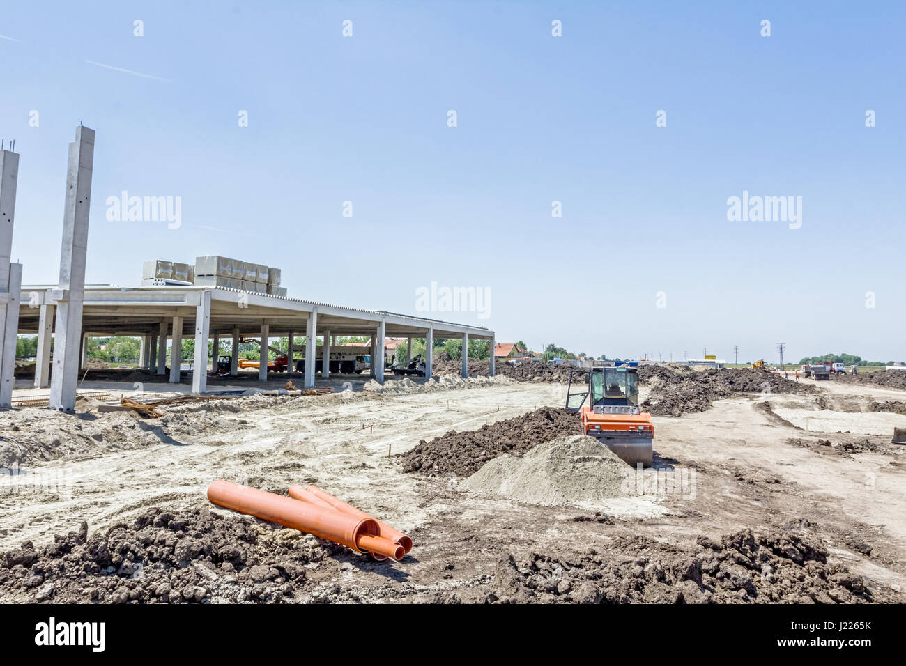 Édifice de béton inachevé, rouleau compresseur est le compactage du sol, mise à niveau at construction site Banque D'Images