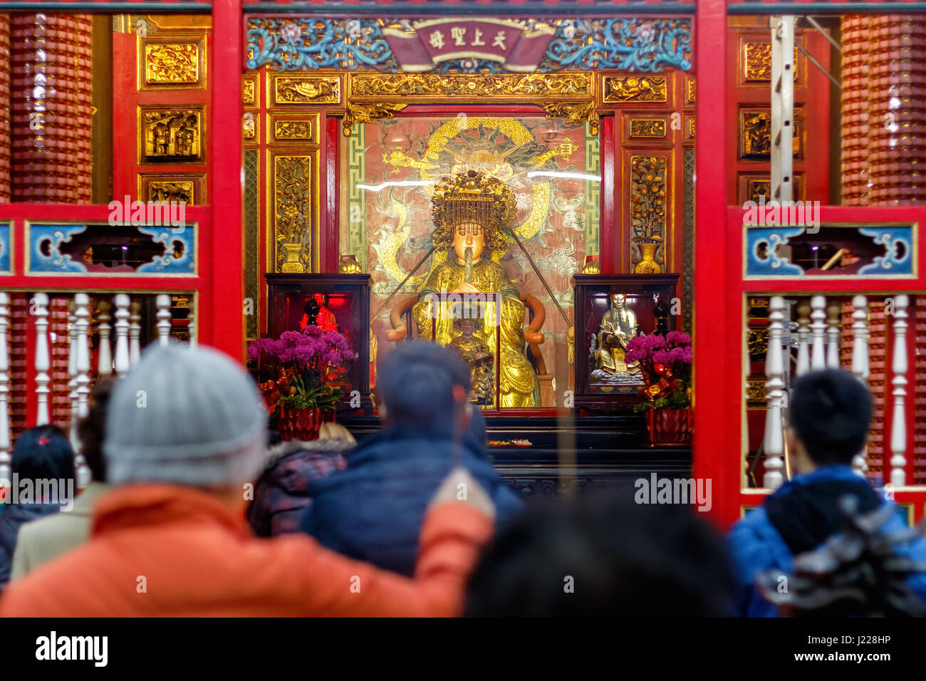 Mazu statue, une déesse de la mer de Chine, vu à travers une foule de prières au temple de Lungshan Manka à Taiwan Banque D'Images