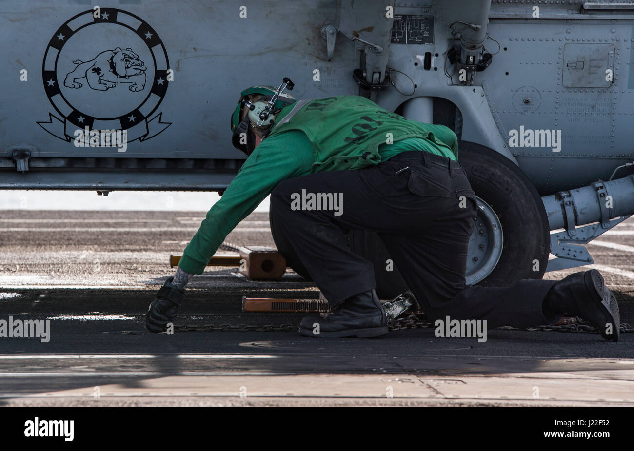 170412-N-QI061-065 OCÉAN ATLANTIQUE (12 avril 2017) l'Aviation-électricien 2e classe Daniel Henson, de Austin, Texas, supprime les chaînes et des cales d'un MH-60S Sea Hawk affecté à l'hélicoptère de chiens poussiéreux de l'Escadron de Combat de mer (HSC) 7 sur le pont d'envol du porte-avions USS Dwight D. Eisenhower (CVN 69) (Ike). Ike et son groupe aéronaval sont en cours participant à un exercice de soutien conçus pour maintenir la disponibilité du déploiement dans le cadre du Plan d'intervention de la flotte optimisée (OFRP). (U.S. Photo par marine Spécialiste de la communication de masse de la classe 3ème Nathan T. Barbe) Banque D'Images