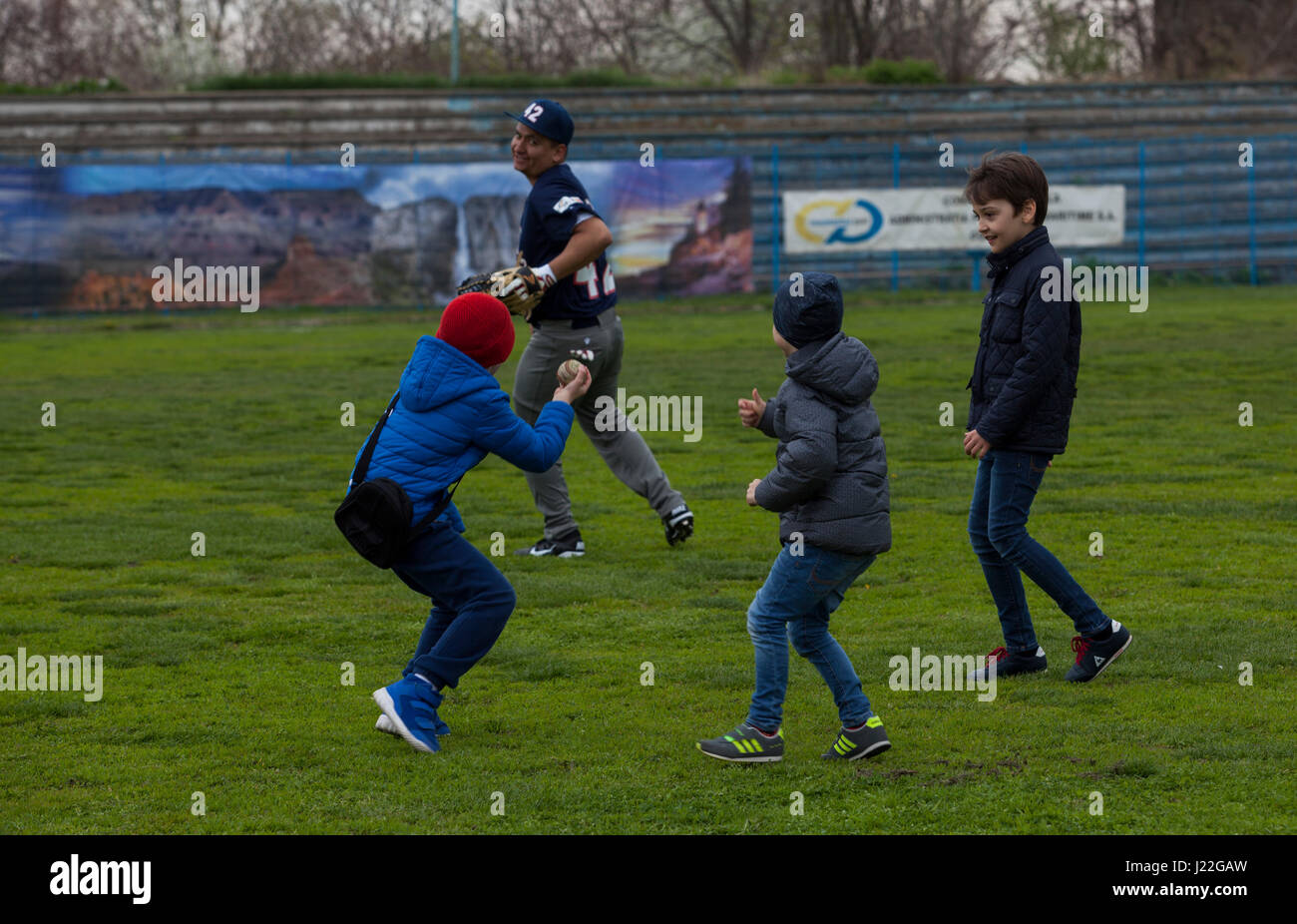 Un U.S. Marine avec la Force de rotation de la mer Noire joue 17,1 prise avec les enfants roumains avant la Jackie Robinson Day match de baseball entre les Marines des États-Unis et d'une équipe roumaine à Constanta, Roumanie 15 Avril, 2017. Le milieu marin et les joueurs roumains portaient tous le maillot numéro 42, en l'honneur du 70e anniversaire de Robinson est devenu le premier joueur afro-américain dans l'histoire de la Ligue Majeure de Baseball. (U.S. Marine Corps photo par le Cpl. Emily Dorumsgaard) Banque D'Images