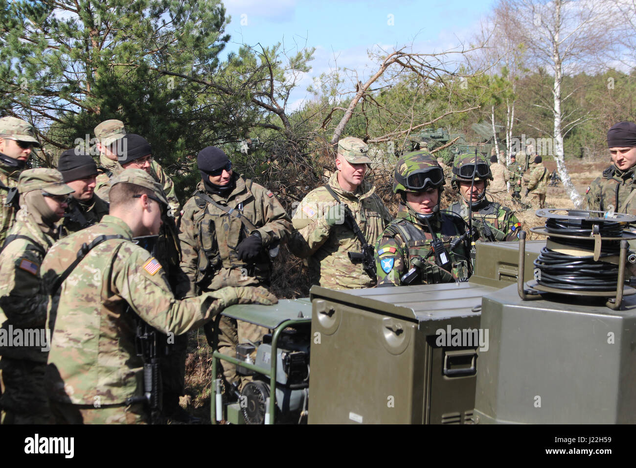 Un soldat roumain montre les fonctions de l'écran radar lié à son canon anti-aérien à d'autres groupe de combat des soldats lors de la formation de l'interopérabilité de la Pologne 18 avril. Cette formation vise à renforcer les pratiques de lutte contre la guerre et d'assurer des connaissances communes à l'échelle du groupe de combat multinationales. La formation unique, composé d'Américains, Britanniques, roumain et polonais soldats, servira de force de dissuasion dans le nord-est de la Pologne à l'appui de l'OTAN vers l'amélioration de la présence. (U.S. Photo de l'armée par le sergent. Zackary vache/libérés) Banque D'Images