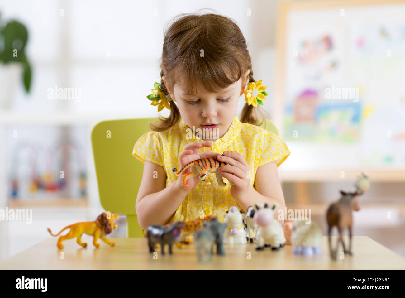 Enfant jouant avec des jouets au tableau à la maternelle ou à la maison Banque D'Images