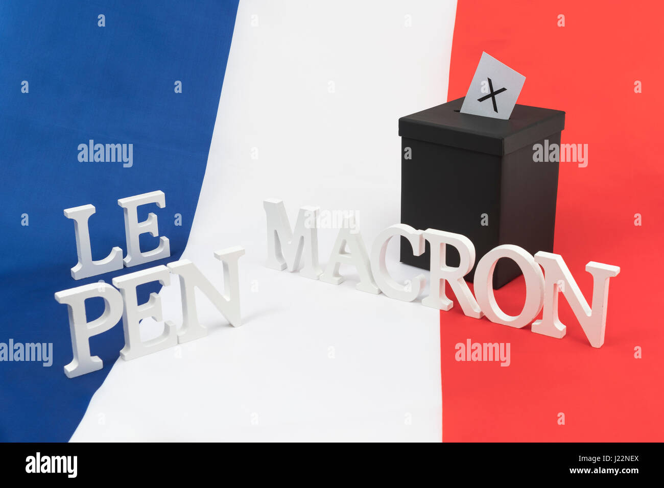 Petite boîte noire sur drapeau tricolore français - comme métaphore visuelle pour les élections générales françaises + noms le Pen & Macron Banque D'Images